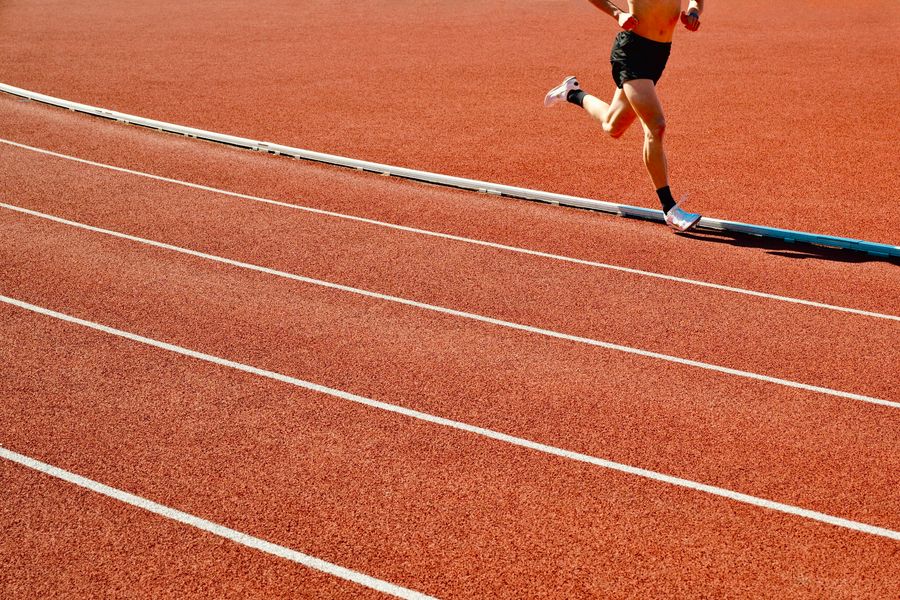 A runner working through repetitions on a red outdoor track